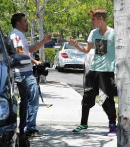 Justin Bieber (right) argues with photographer Jose Duran near Los Angeles in May 2012 after Bieber allegedly kicked Duran. Bieber lost a shoe in the mishap. (nydailynews.com photo)