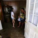 Thirteen-year-old Ciearra Toomer checks on her mother Teresa Harbison, who was overcome with emotion, inside their flood damaged home in St. Amant