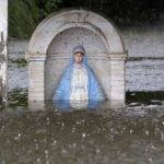 A statue of the Virgin Mary is seen partially submerged in flood water as it rains in Sorrento