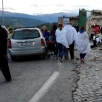 People stand along a road following a quake in Amatrice