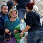 A woman cries after been rescued from her home following a quake in Amatrice