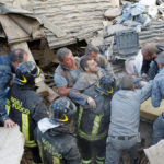 A man is carried away after having been rescued alive from the ruins following an earthquake in Amatrice