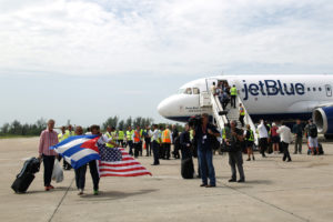 Passengers of a JetBlue aeroplane, the first commercial scheduled flight between the United States and Cuba in more than 50 years, carry U.S. and Cuban national flags after it landed at the Abel Santamaria International Airport in Santa Clara, Cuba, August 31, 2016. REUTERS/Alexandre Meneghini