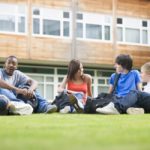 storyblocks/college-students-sitting-and-talking-on-campus-lawn_HFuT06ABo
