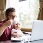 graphicstock-young-handsome-man-with-notebook-in-cafe-sitting-at-the-table-drinking-coffee-holding-his-son-in-his-lap_r_Z_Dr_LMZ