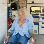 storyblocks/Injured senior man sitting on stretcher in ambulance car