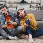 freepik/young-couple-wearing-headphone-sitting-floor-near-sofa-playing-video-game_23-2148152845