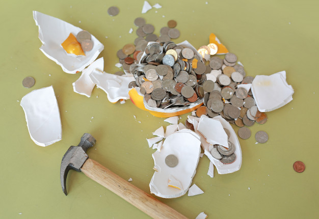 https://www.freepik.com/premium-photo/broken-piggy-bank-with-hammer-coins-table_6981708.htm