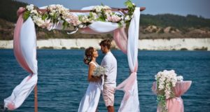 https://www.freepik.com/premium-photo/bride-groom-white-clothes-with-bouquet-white-flowers-stand-arch-flowers-fabric-against-background-blue-lake-white-sand_9929327.htm