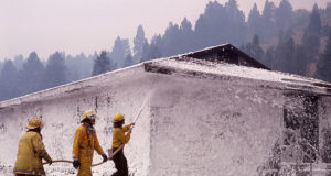 Crew foaming YCC dormitory at Mammoth Hot Springs during 1988 Yellowstone fire, image taken by Jim Peaco, September 10, 1988 and retrieved from the following page [1] of the Yellowstone Digital Slide Files archives which are all in the public domain [2