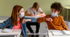 https://www.freepik.com/free-photo/front-view-children-with-medical-masks-doing-elbow-salute-class_12367048.htm?query=covid%20school