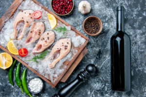 https://www.freepik.com/free-photo/top-view-raw-fish-slices-with-ice-lemon-slices-wood-board-wine-bottle-table_17235741.htm#page=1&query=fish%20wine&position=28
