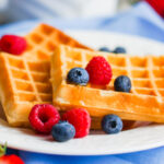 belgian-waffles-with-berries-on-rustic-background-SBI-300780931