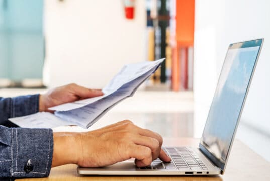https://www.vecteezy.com/photo/7187730-businessman-checking-a-typed-report-or-document-as-he-sits-working-on-paperwork-at-a-laptop-computer-paying-bills-online-on-laptop