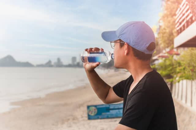 https://www.vecteezy.com/photo/7311911-man-drinking-water-from-a-bottle-sit-outside-next-to-the-beach