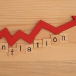 Word inflations assembled from wooden letters game and red arrow on wooden background