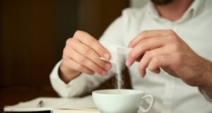 https://www.vecteezy.com/photo/27031225-close-up-of-an-unrecognizable-man-in-a-white-shirt-sprinkling-sugar-from-sticks-into-a-white-ceramic-cup-with-a-freshly-brewed-coffee-drink-sitting-at-a-wooden-table-and-enjoying-a-coffee-break